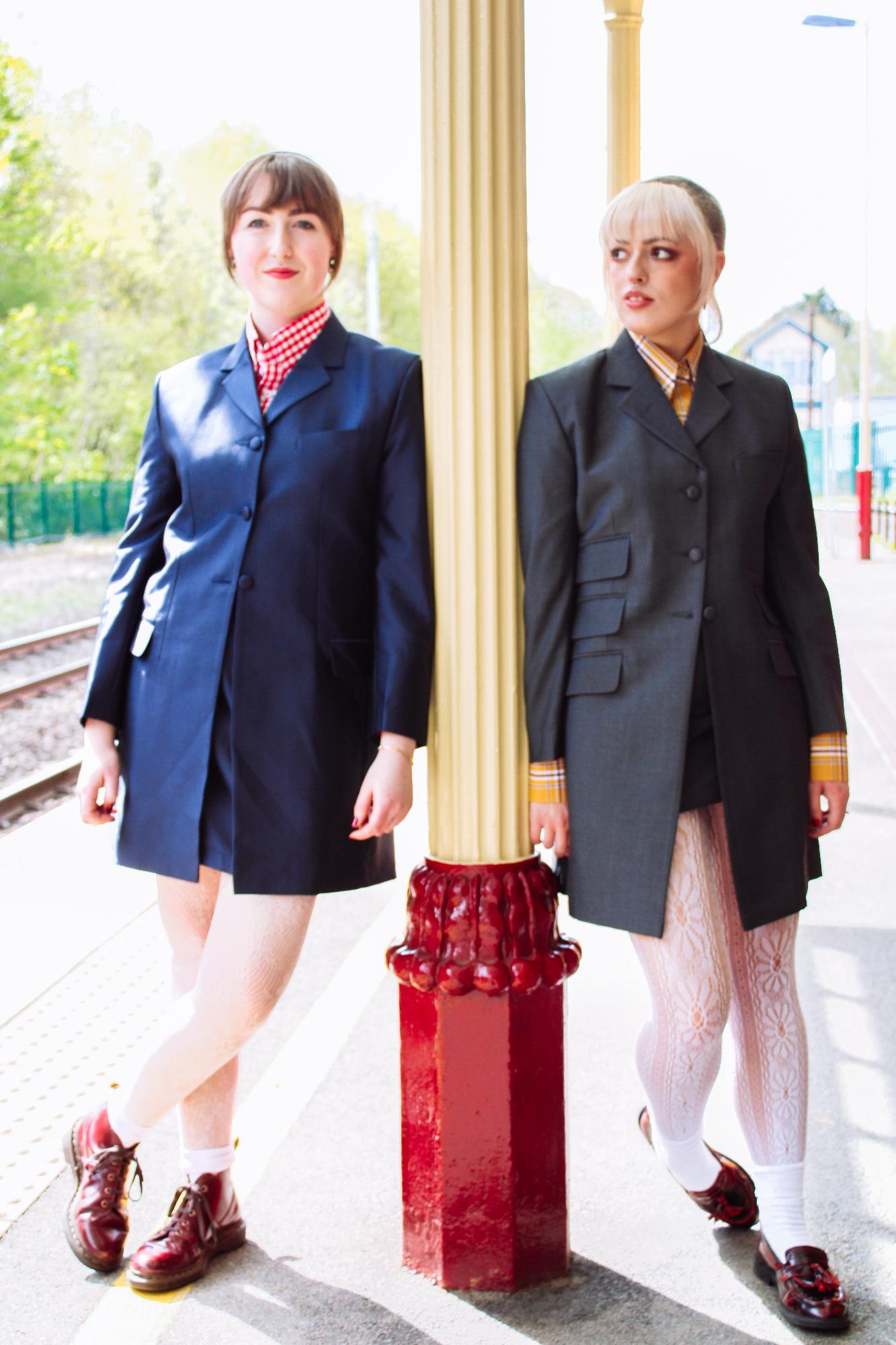 Two models wearing mod jackets on a train platform