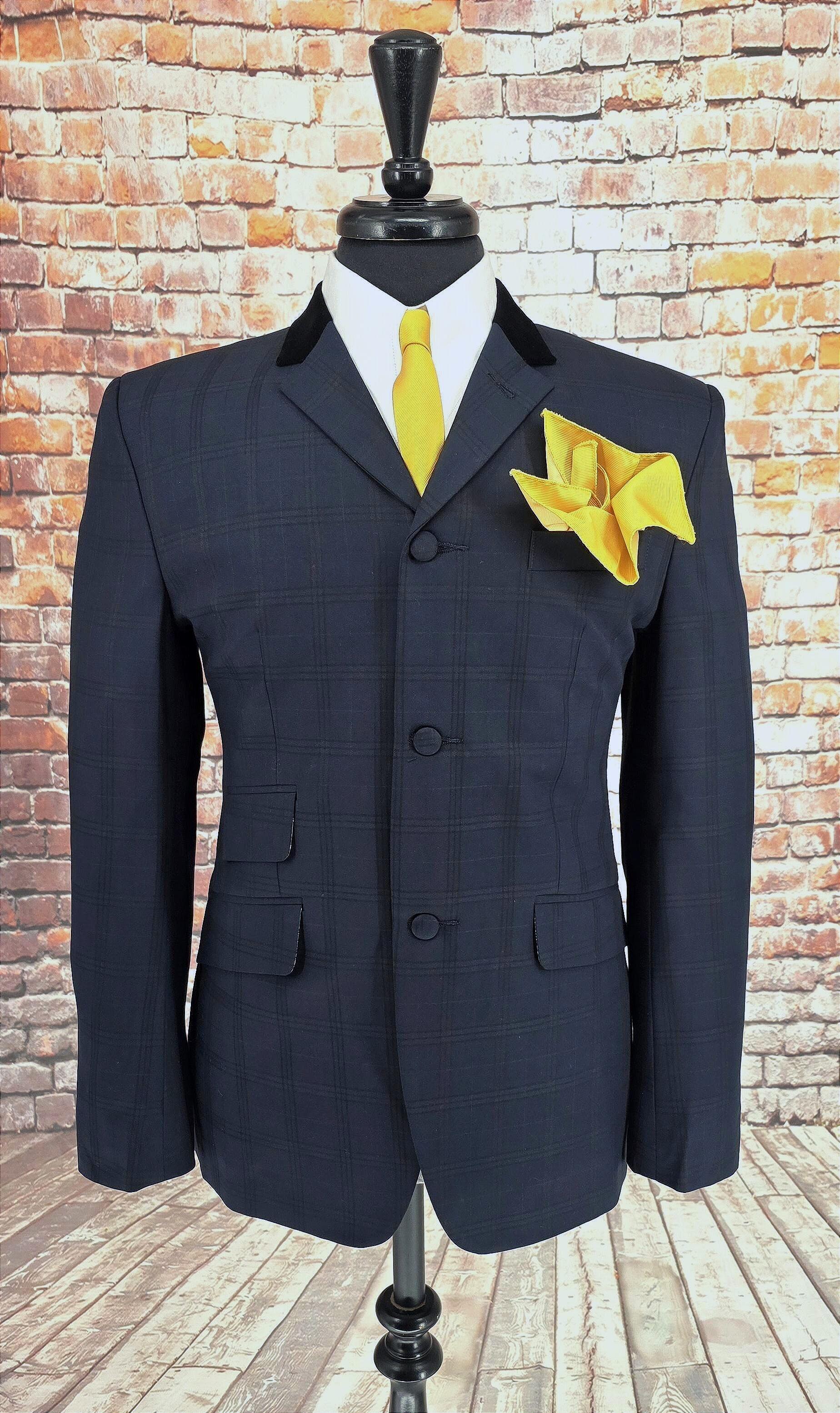 Ernest suit jacket on mannequin with velvet‑trimmed lapel and yellow accessories
