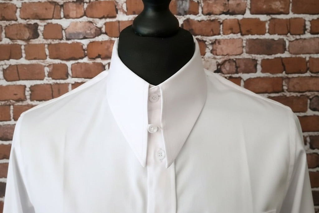 White shirt on a black mannequin against a brick wall background